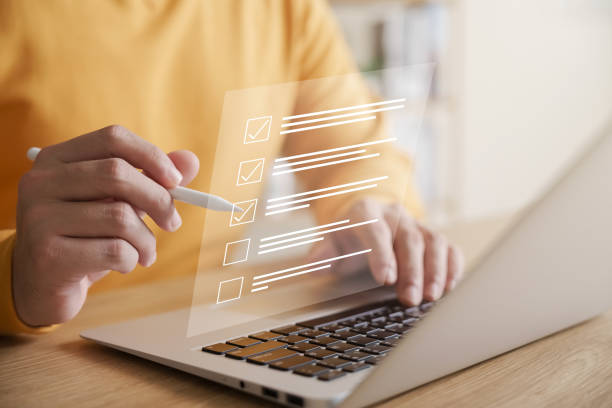 Businessman using laptop doing online checklist survey